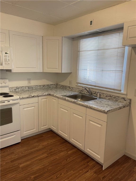 kitchen featuring white cabinetry, dark wood-type flooring, white appliances, and sink