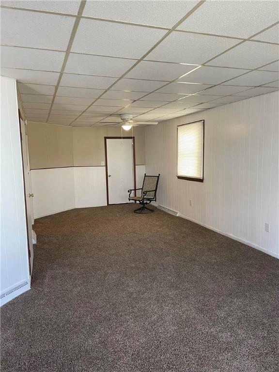 empty room with a drop ceiling and carpet floors