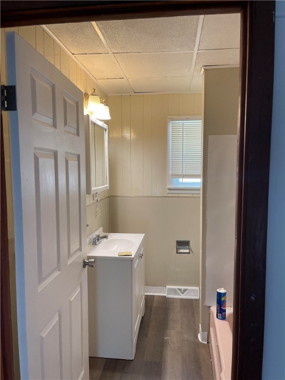 bathroom featuring vanity, wood-type flooring, and a paneled ceiling