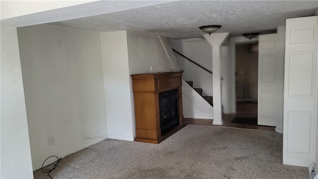 unfurnished living room featuring carpet and a textured ceiling