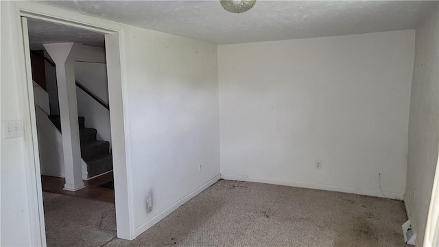 carpeted spare room with a textured ceiling