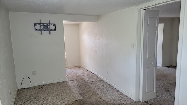 unfurnished room featuring light carpet