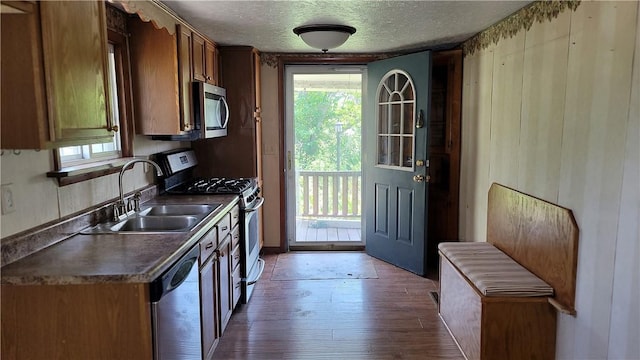 kitchen with sink, hardwood / wood-style floors, a textured ceiling, and appliances with stainless steel finishes