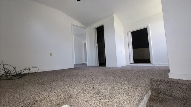 carpeted spare room with lofted ceiling