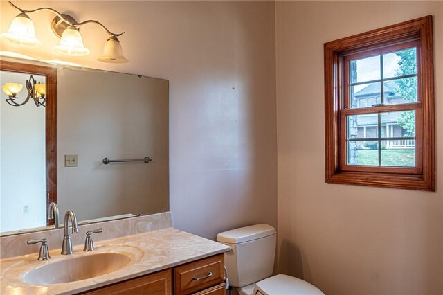 bathroom with a healthy amount of sunlight, toilet, and vanity