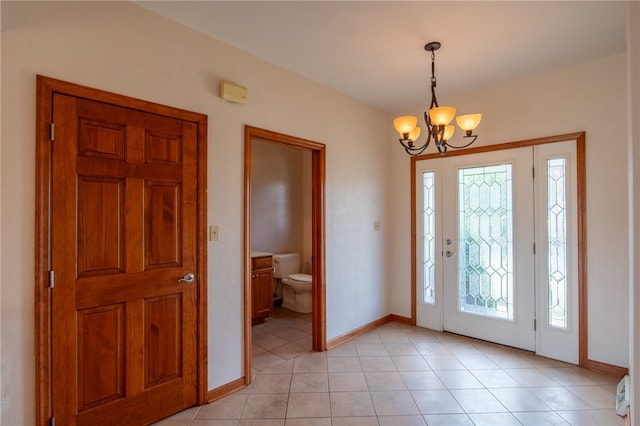 tiled entryway with a chandelier