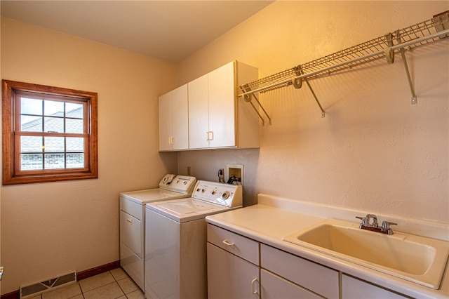 washroom featuring cabinets, light tile patterned floors, washing machine and dryer, and sink