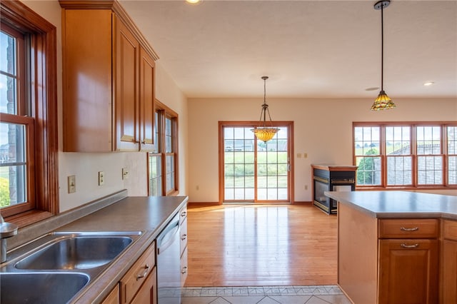 kitchen featuring a healthy amount of sunlight, light hardwood / wood-style flooring, and hanging light fixtures