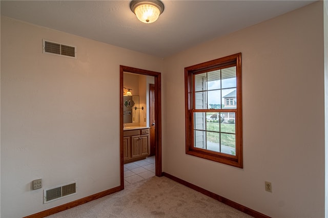 interior space with connected bathroom and light tile patterned floors