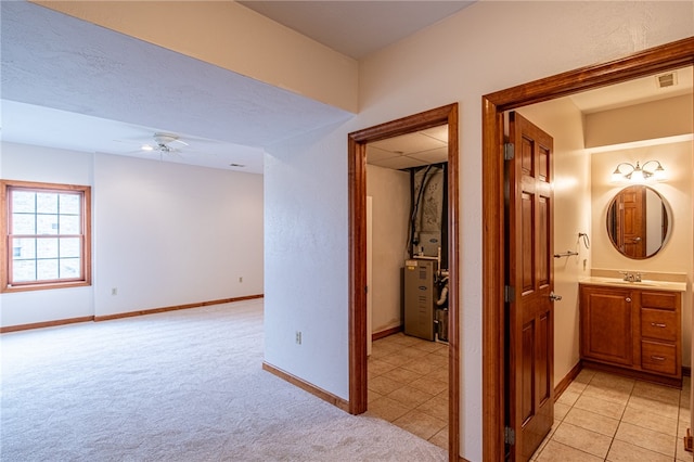 hall featuring light colored carpet and sink