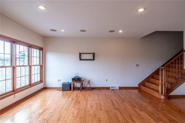 unfurnished living room with a wealth of natural light and wood-type flooring