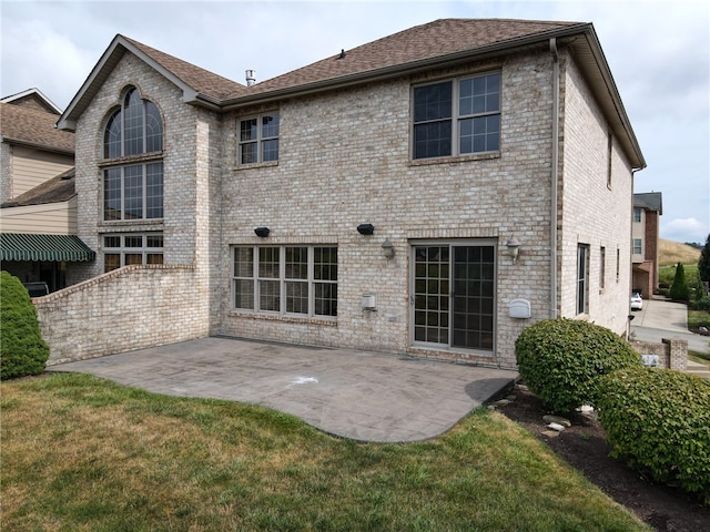 back of property featuring a patio and a yard