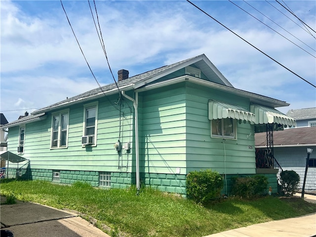 view of side of home featuring a yard and cooling unit