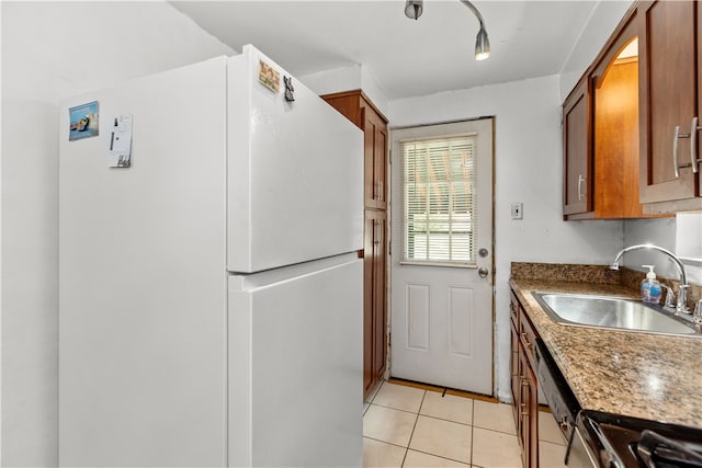 kitchen featuring light tile patterned floors, sink, and white fridge