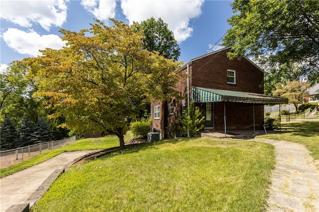 view of front of property featuring central AC unit and a front yard