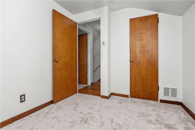 unfurnished bedroom with a closet and light colored carpet