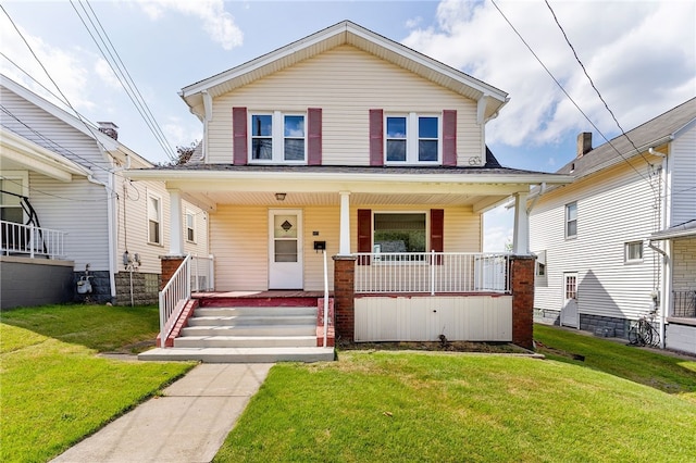 view of front of home with a front yard and covered porch