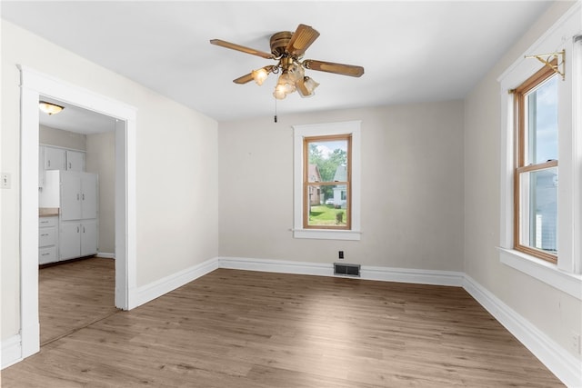 spare room with light wood-type flooring and ceiling fan