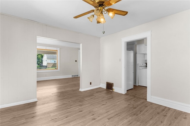 spare room featuring washer / clothes dryer, ceiling fan, and hardwood / wood-style floors