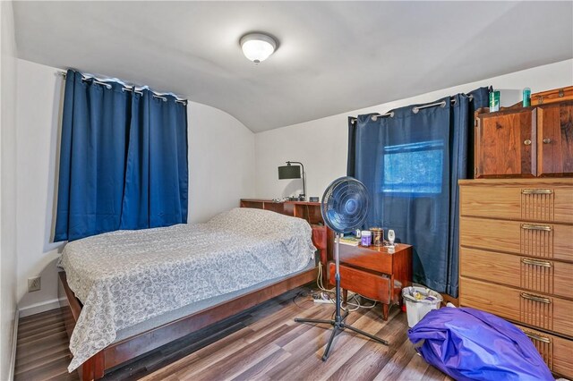 bedroom with lofted ceiling and dark wood-type flooring