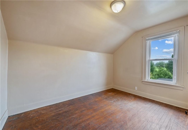 bonus room with plenty of natural light, dark wood-type flooring, and vaulted ceiling