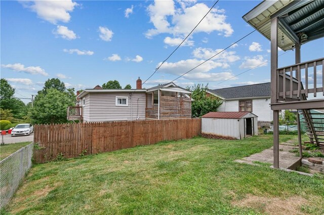 view of yard featuring a deck and a storage shed