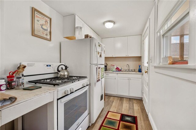 kitchen with light hardwood / wood-style floors, sink, white cabinetry, and white range with gas cooktop