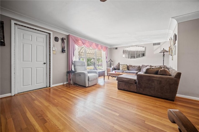 living room with light wood-type flooring and crown molding