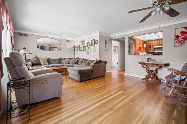 living room with crown molding, ceiling fan, and light hardwood / wood-style floors