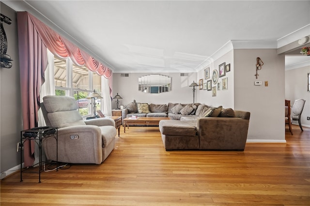 living room with ornamental molding and light hardwood / wood-style flooring