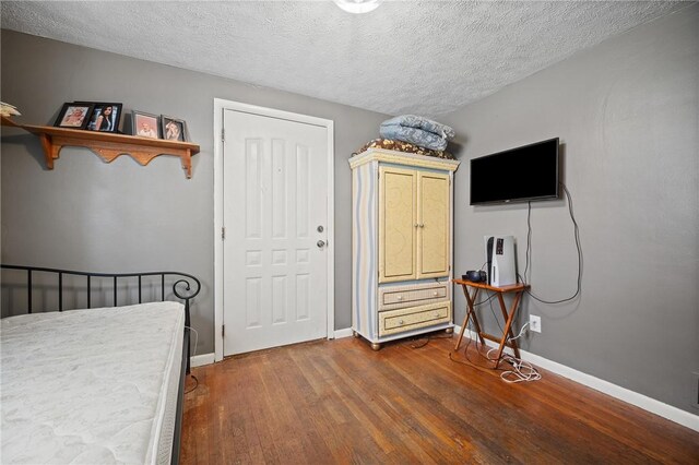 bedroom featuring a textured ceiling and wood-type flooring