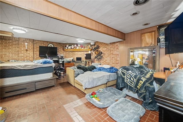 bedroom featuring wood walls and brick wall