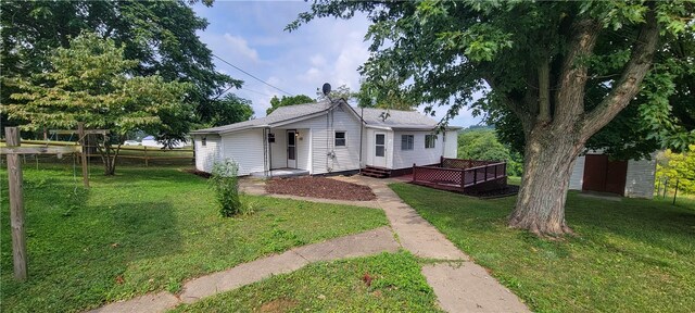 view of front of property with a deck and a front lawn