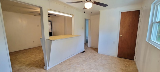 interior space with ornamental molding and ceiling fan