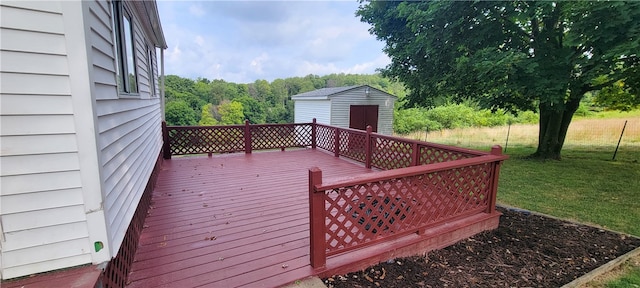 wooden terrace with a lawn and a storage unit