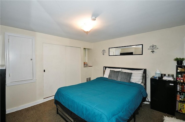 bedroom with a closet and dark colored carpet