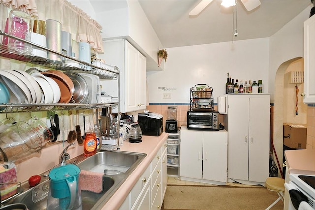 kitchen with white cabinetry, ceiling fan, and sink