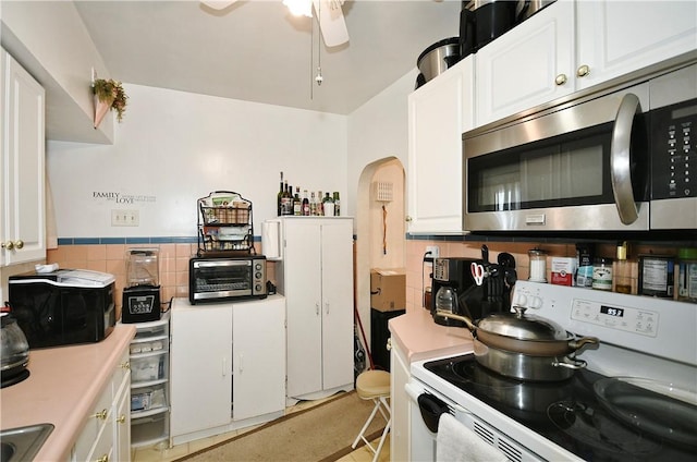 kitchen with electric stove, white cabinetry, and ceiling fan