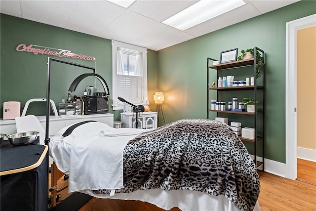 bedroom featuring light wood-type flooring and a paneled ceiling