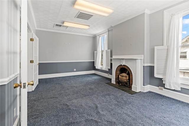 unfurnished living room featuring ornamental molding, a brick fireplace, and a wealth of natural light