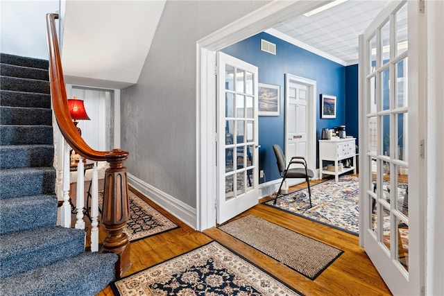 interior space with french doors, hardwood / wood-style flooring, and ornamental molding