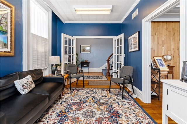 interior space with light hardwood / wood-style flooring, crown molding, and french doors