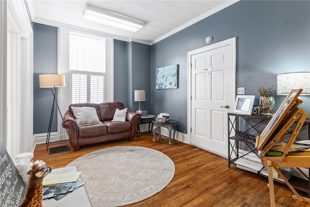 living area with ornamental molding and hardwood / wood-style floors