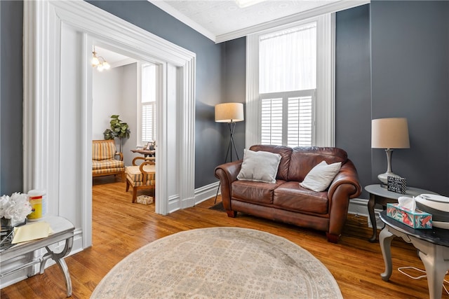 living room with crown molding and light wood-type flooring