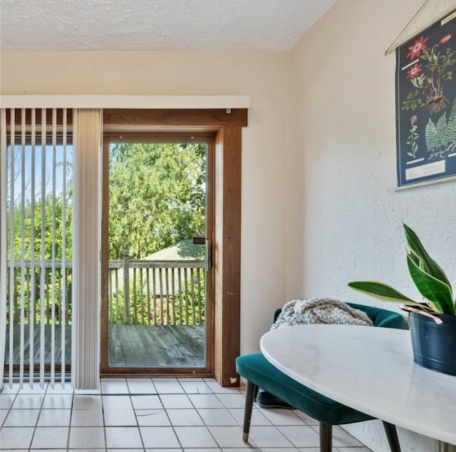 doorway with a textured ceiling and light tile patterned floors