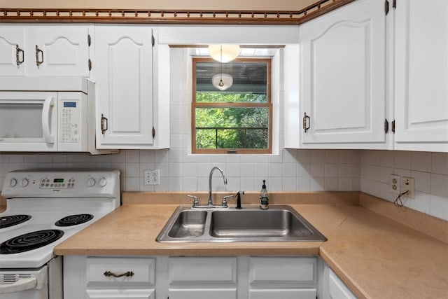 kitchen with white appliances, sink, decorative backsplash, and white cabinets