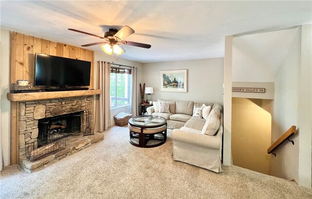 carpeted living room featuring a fireplace and ceiling fan