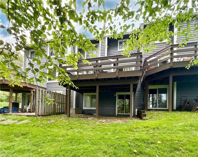 rear view of property featuring a deck and a lawn