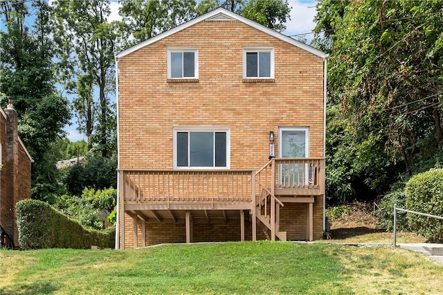 rear view of house with a lawn and a wooden deck