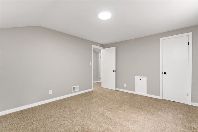 unfurnished room featuring vaulted ceiling and carpet floors